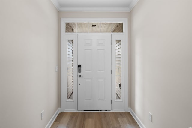 foyer entrance featuring light wood-style flooring, baseboards, and ornamental molding