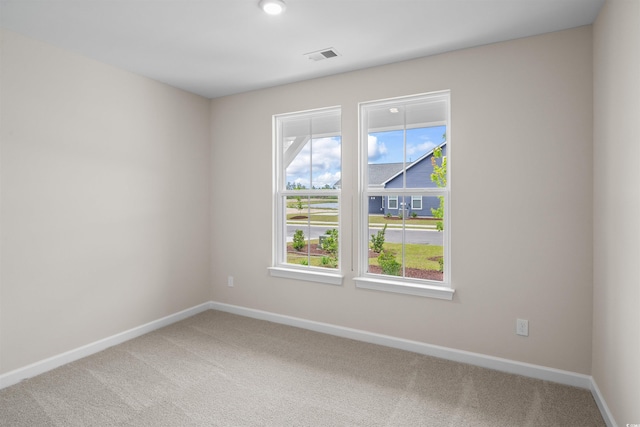 unfurnished room featuring light colored carpet and baseboards