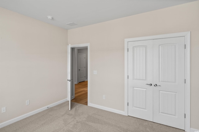 unfurnished bedroom with carpet flooring, baseboards, and a closet