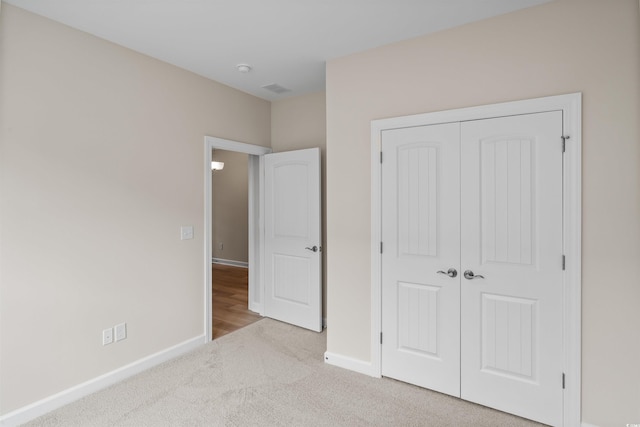 unfurnished bedroom featuring carpet floors, a closet, and baseboards