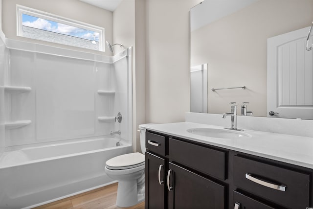 full bathroom featuring toilet, wood finished floors, vanity, and washtub / shower combination