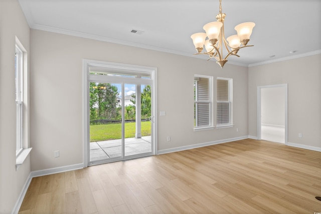 spare room featuring a chandelier, light wood-style flooring, ornamental molding, and baseboards