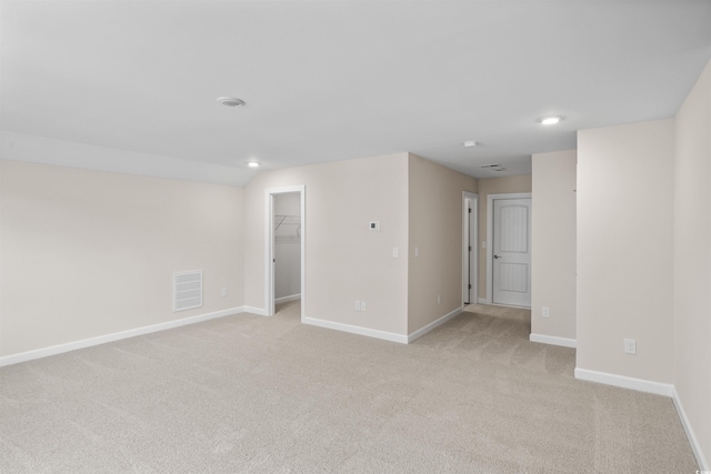 empty room with light carpet, baseboards, and recessed lighting