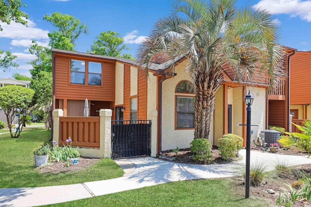 view of front of property featuring cooling unit, a gate, and stucco siding