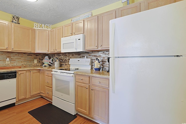 kitchen with white appliances, light brown cabinets, light countertops, light wood-type flooring, and backsplash