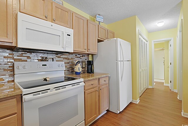 kitchen featuring white appliances, tasteful backsplash, light wood-style floors, light brown cabinetry, and baseboards
