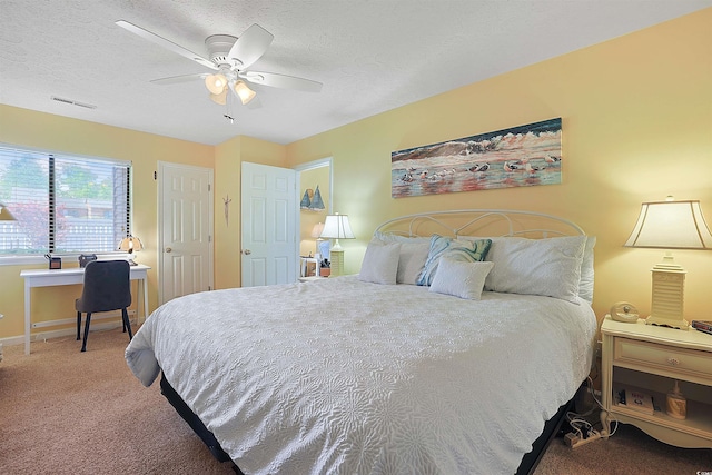 bedroom with carpet floors, a textured ceiling, baseboards, and a ceiling fan