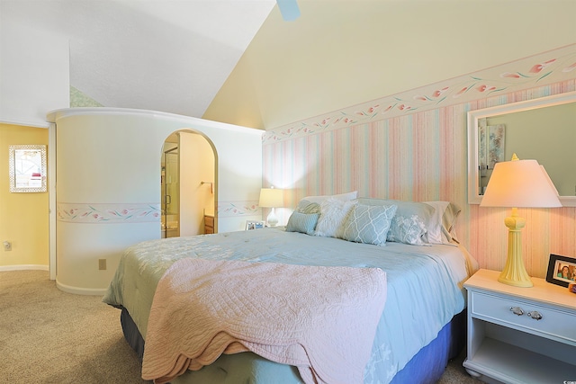 carpeted bedroom with vaulted ceiling and arched walkways