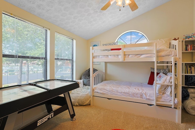 carpeted bedroom with a textured ceiling, lofted ceiling, and ceiling fan