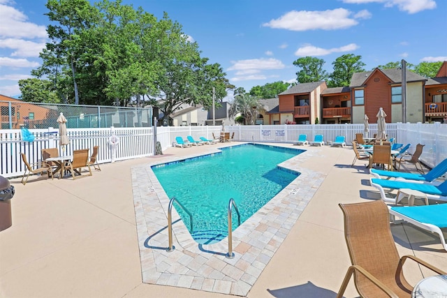 community pool featuring a patio area, fence, a residential view, and outdoor dining space