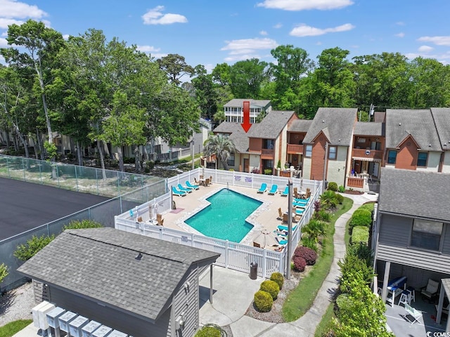 community pool with fence, a residential view, and a patio area