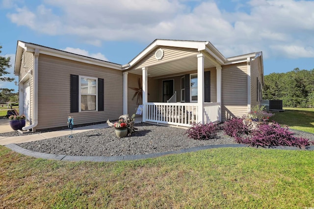 manufactured / mobile home featuring covered porch and a front lawn