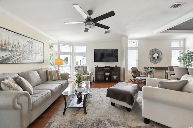 living area with crown molding, dark wood-style flooring, and ceiling fan