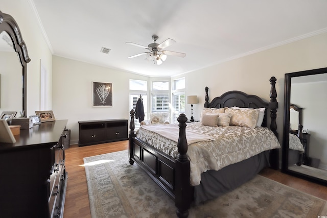 bedroom featuring wood finished floors, crown molding, ceiling fan, and baseboards