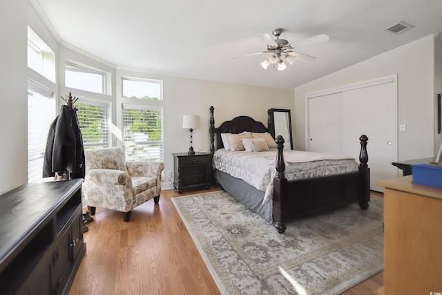 bedroom featuring ornamental molding, wood finished floors, a closet, and a ceiling fan