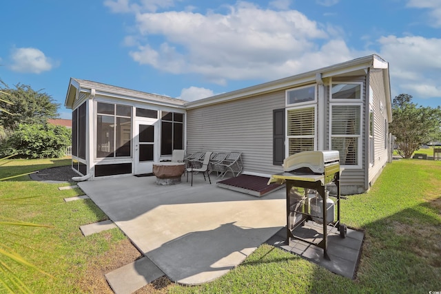 rear view of property featuring a patio area, a sunroom, and a yard