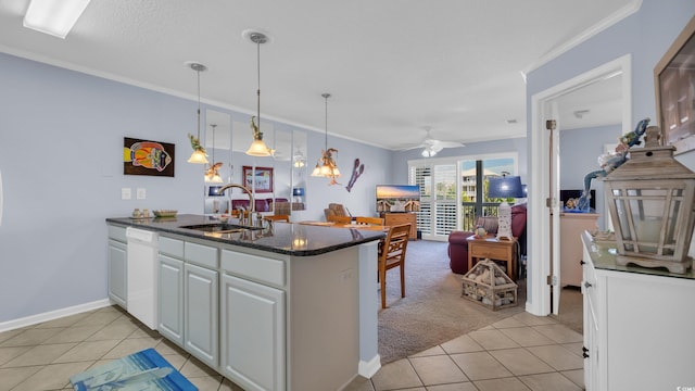 kitchen with ornamental molding, light tile patterned flooring, a sink, white cabinetry, and a peninsula
