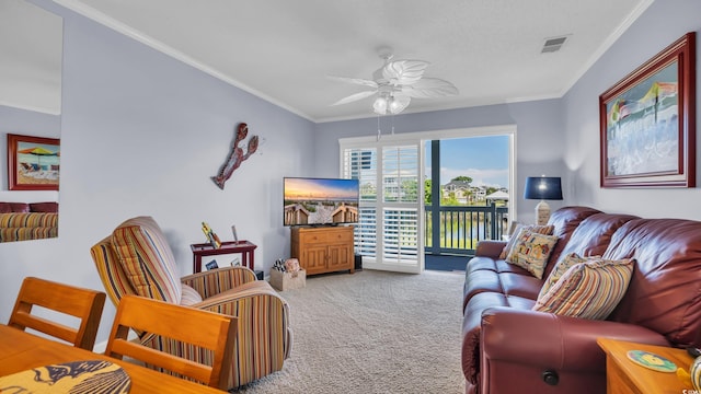 living area featuring a ceiling fan, visible vents, crown molding, and carpet floors