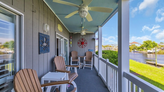 balcony with a water view and a ceiling fan