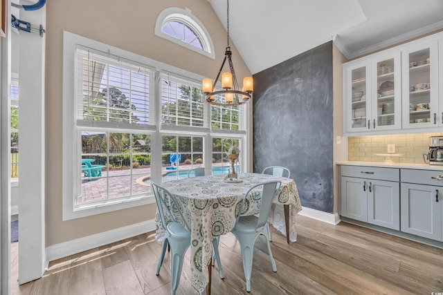1203 Crooked Oak Dr, Pawleys Island, SC 29585 - dining area with an inviting chandelier, baseboards, high vaulted ceiling, and light wood finished floors