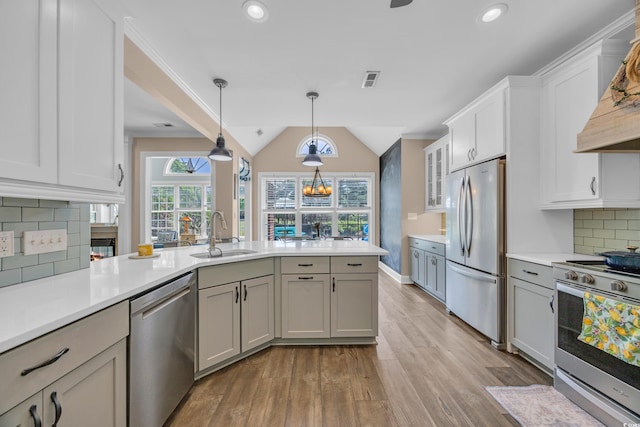 1203 Crooked Oak Dr, Pawleys Island, SC 29585 - kitchen featuring pendant lighting, stainless steel appliances, a sink, light countertops, and light wood-type flooring
