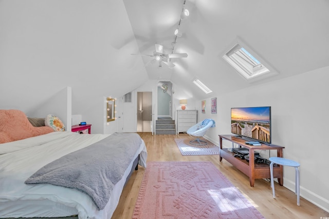 1203 Crooked Oak Dr, Pawleys Island, SC 29585 - bedroom featuring baseboards, lofted ceiling with skylight, rail lighting, and light wood-type flooring