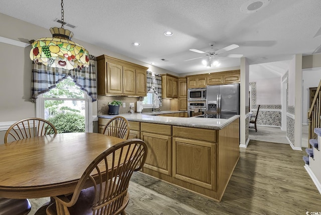 552 Enoree Ct, Myrtle Beach, SC 29588 - kitchen featuring a peninsula, a textured ceiling, stainless steel appliances, and wood finished floors