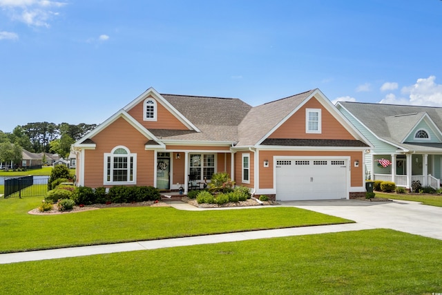 craftsman inspired home with a porch, roof with shingles, fence, driveway, and a front lawn