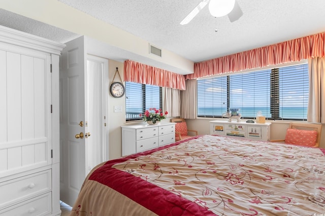 bedroom with a textured ceiling and ceiling fan