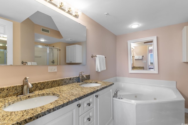full bathroom with a shower stall, a jetted tub, and double vanity
