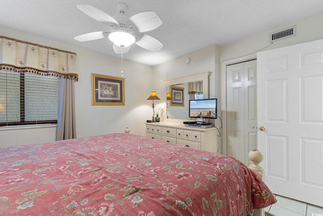 bedroom with a closet, ceiling fan, and light tile patterned floors