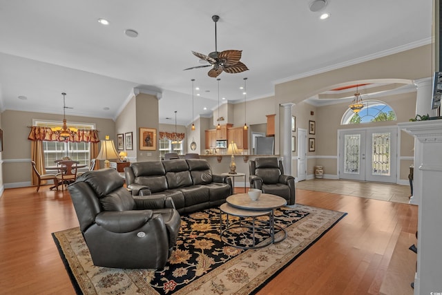 living room with decorative columns, ceiling fan, arched walkways, a chandelier, and recessed lighting