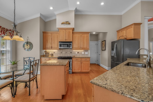 kitchen with stainless steel appliances, a sink, light stone countertops, a center island, and backsplash