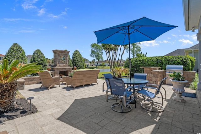 view of patio / terrace with area for grilling, outdoor dining area, exterior kitchen, and an outdoor living space with a fireplace