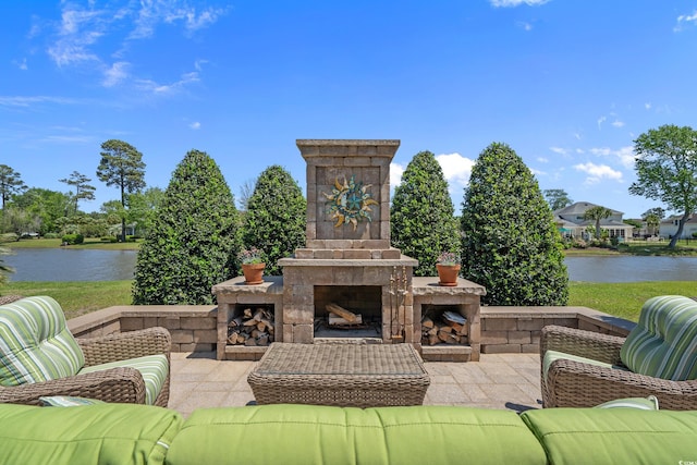 view of patio featuring a water view and an outdoor living space with a fireplace