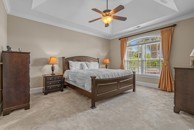carpeted bedroom featuring a raised ceiling, baseboards, crown molding, and a ceiling fan