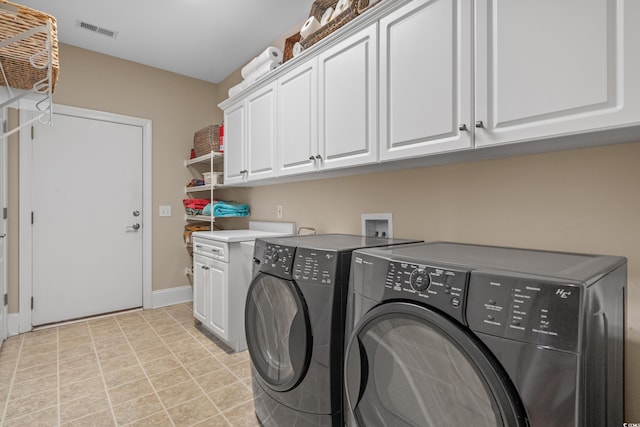 washroom with cabinet space, washer and dryer, and baseboards