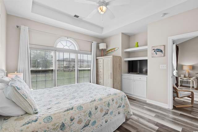 5751 Oyster Catcher Dr Unit 334, North Myrtle Beach, SC 29582 - bedroom featuring a raised ceiling, light wood-style floors, and ceiling fan