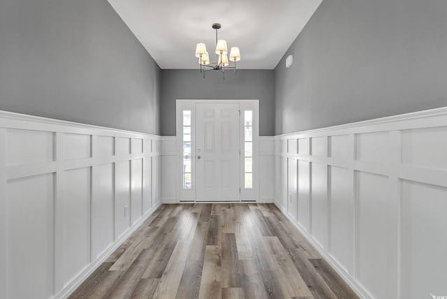 383 Hayloft Cir, Conway, SC 29526 - foyer entrance with a decorative wall, a chandelier, wood finished floors, and a wainscoted wall