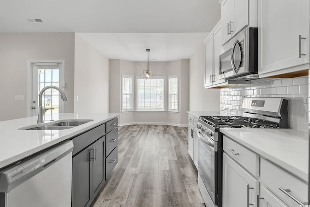383 Hayloft Cir, Conway, SC 29526 - kitchen with stainless steel appliances, a sink, light wood-type flooring, white cabinets, and baseboards