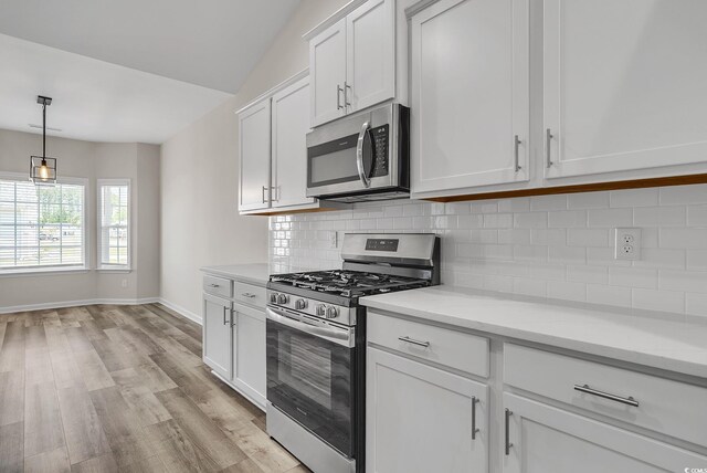 383 Hayloft Cir, Conway, SC 29526 - kitchen with appliances with stainless steel finishes, light wood-style flooring, backsplash, baseboards, and white cabinetry