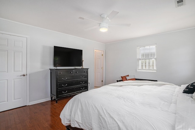 bedroom featuring crown molding, multiple windows, wood finished floors, baseboards, and a ceiling fan