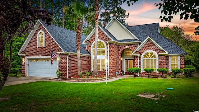 180 Waterhall Dr, Murrells Inlet, SC 29576 - traditional-style home with brick siding, roof with shingles, a lawn, a garage, and concrete driveway