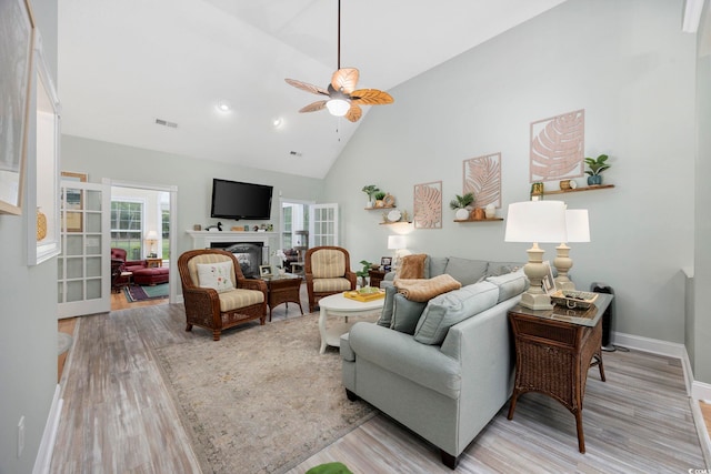 180 Waterhall Dr, Murrells Inlet, SC 29576 - living area featuring light wood-type flooring, ceiling fan, a glass covered fireplace, high vaulted ceiling, and baseboards