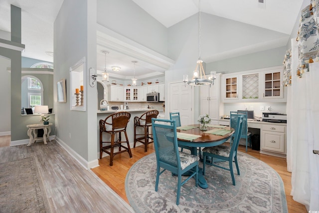 180 Waterhall Dr, Murrells Inlet, SC 29576 - dining room with a chandelier, light wood-style floors, high vaulted ceiling, and baseboards