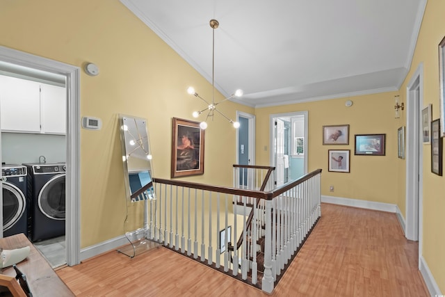 4003 N Ocean Blvd, Myrtle Beach, SC 29577 - corridor featuring washing machine and dryer, ornamental molding, an upstairs landing, and light wood-style floors