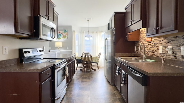 kitchen with stainless steel appliances, a sink, dark countertops, and dark brown cabinetry