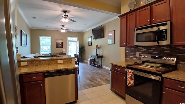 kitchen with appliances with stainless steel finishes, crown molding, decorative backsplash, ceiling fan, and light stone counters