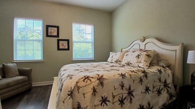 bedroom with dark wood-type flooring and baseboards