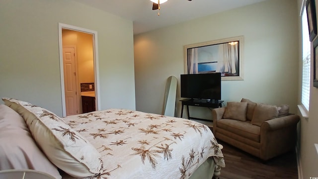 bedroom with dark wood finished floors and connected bathroom